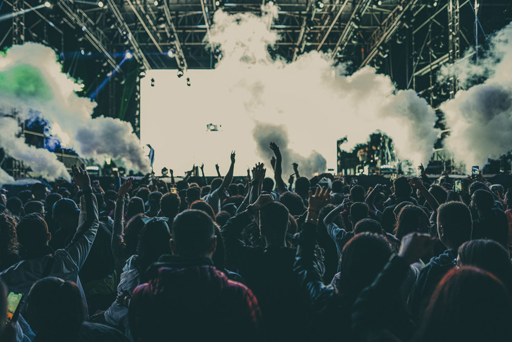 Festival crowd with hands in the air in front of the stage